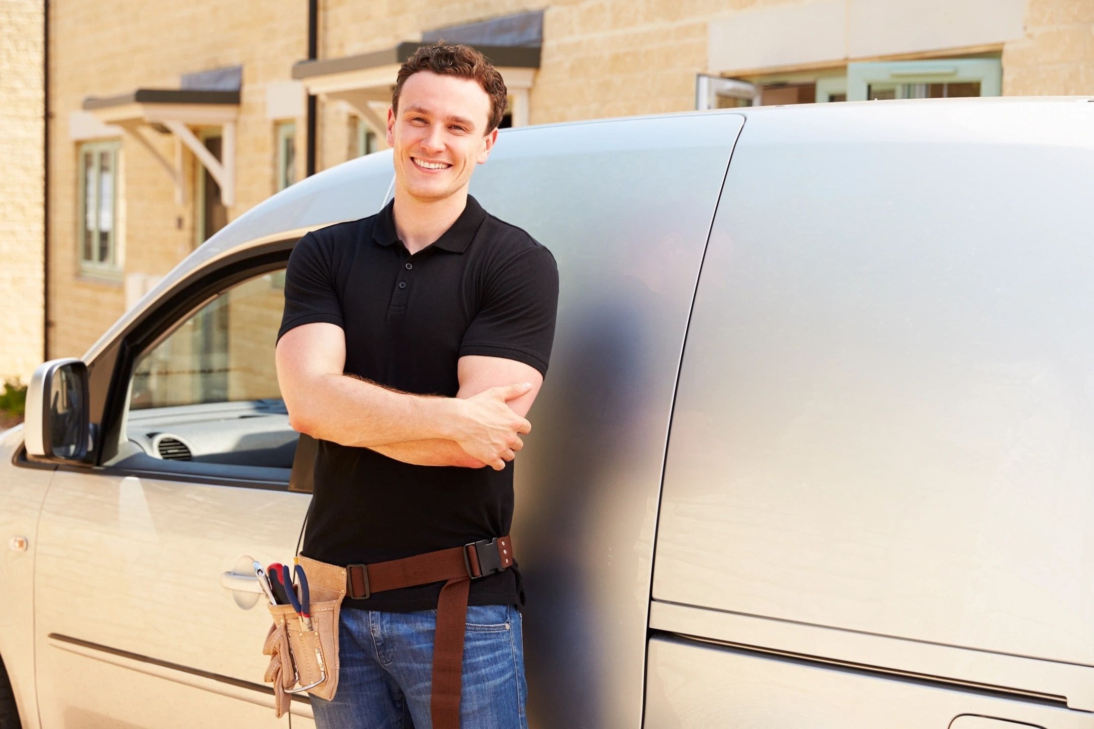 A man standing next to a silver van.